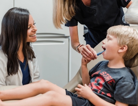 Grove City dentist talking to young boy during dental visit